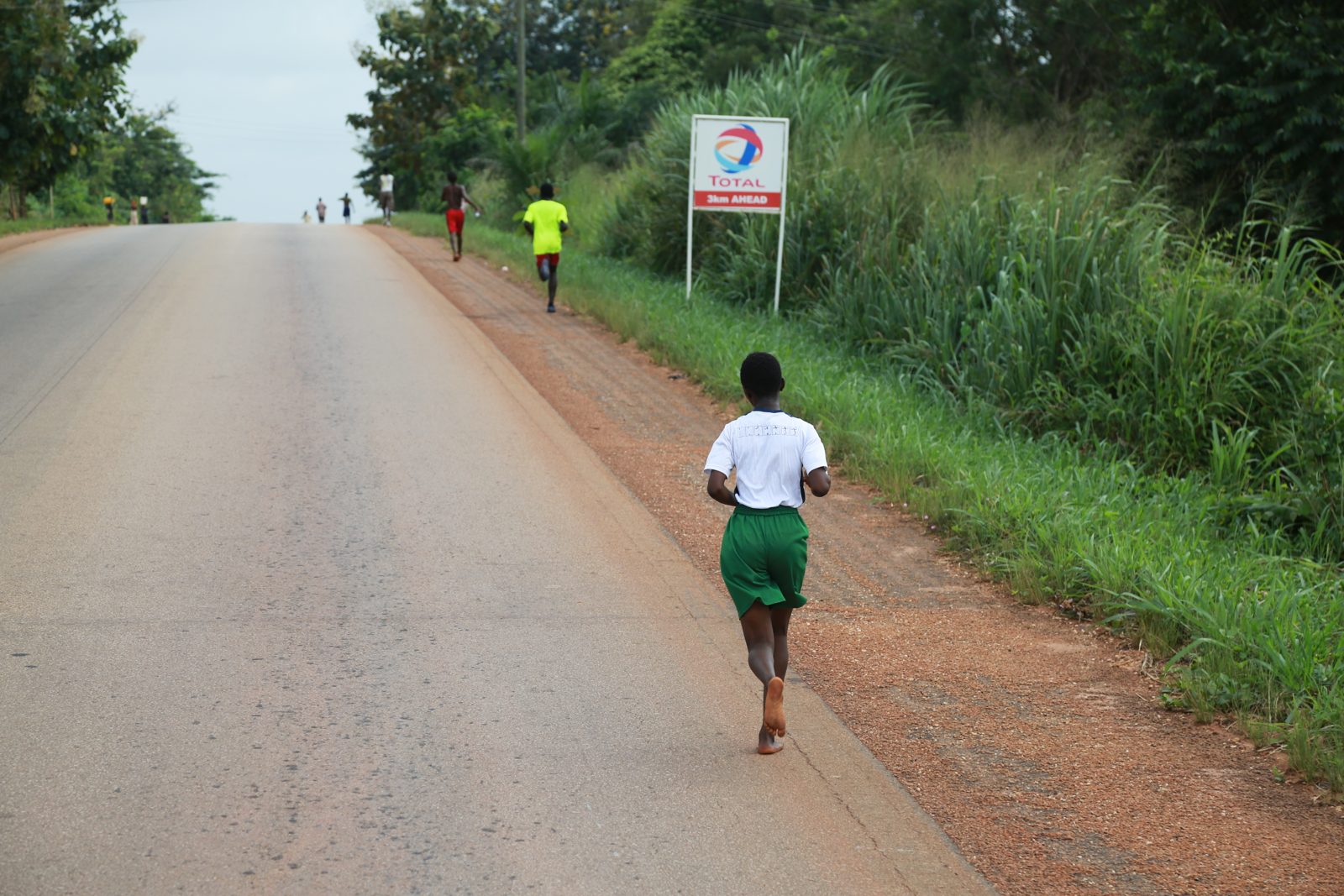 Two runners spread out in the chase down the road
