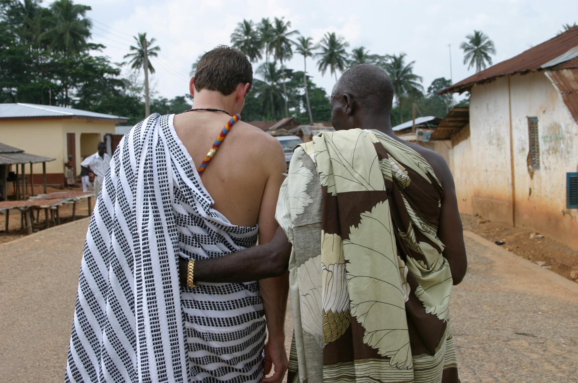 A volunteer and community leader walking together, arm in arm